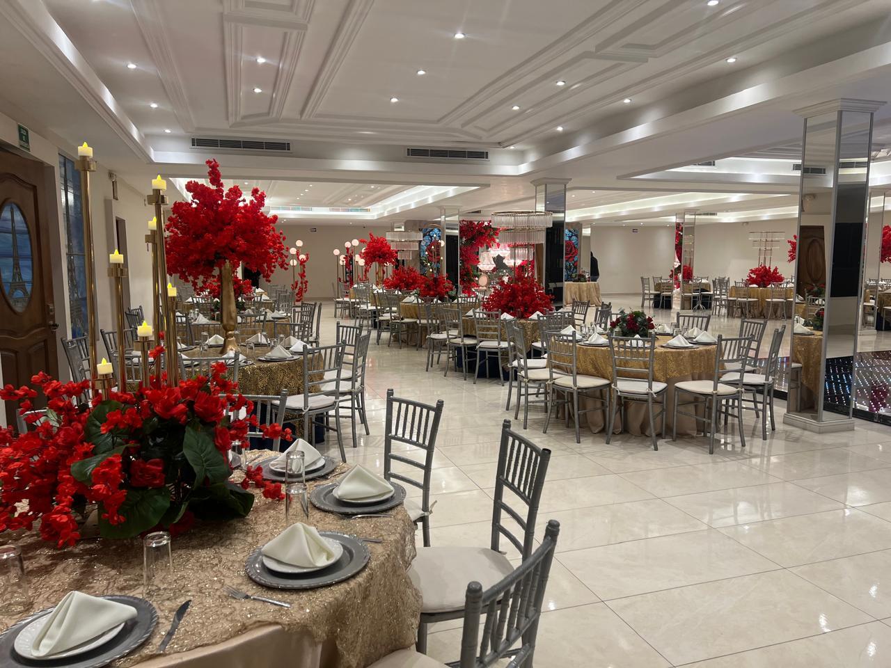 Mesas con flores rojas junto a la pista del Salón Paris